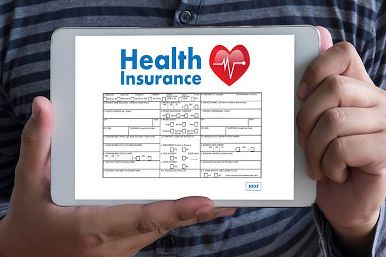 年轻男子拿着平板电脑与健康保险信息。