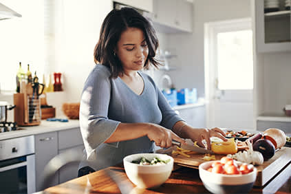 年轻女子在厨房砧板，使健康的一餐。
