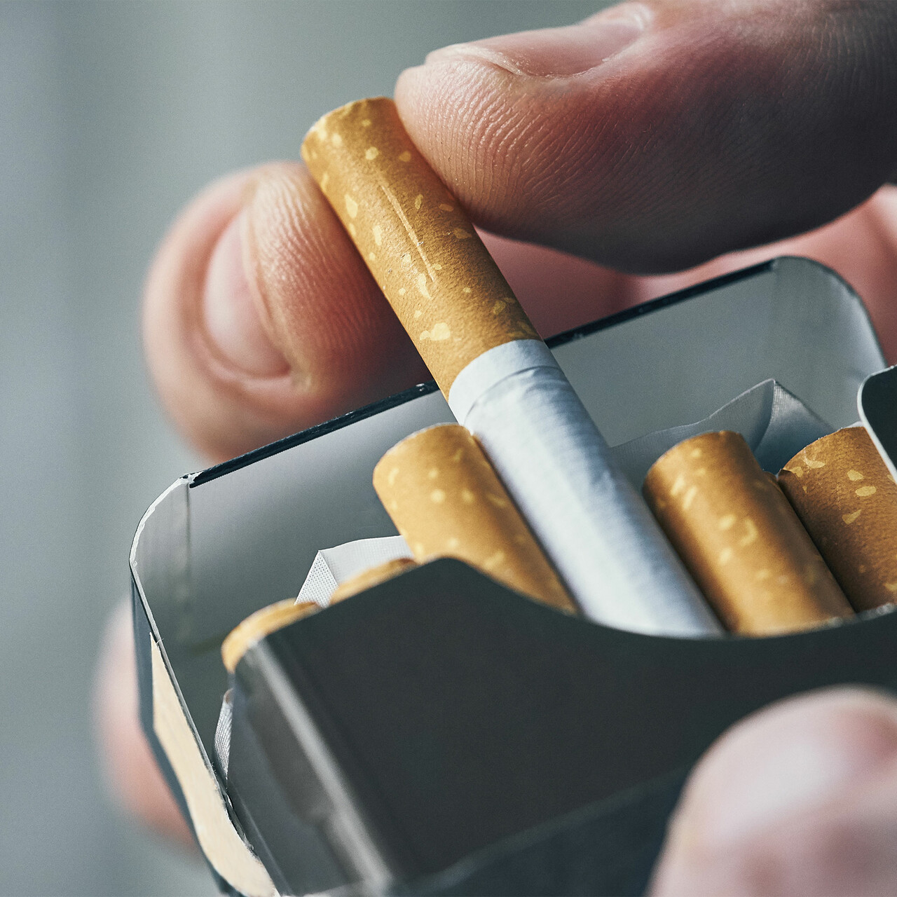 一个特写镜头的人拿着香烟包装上