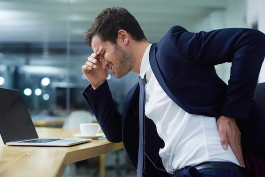 Man in pain at office desk.