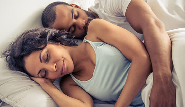 年轻夫妇在床上睡觉的形象。