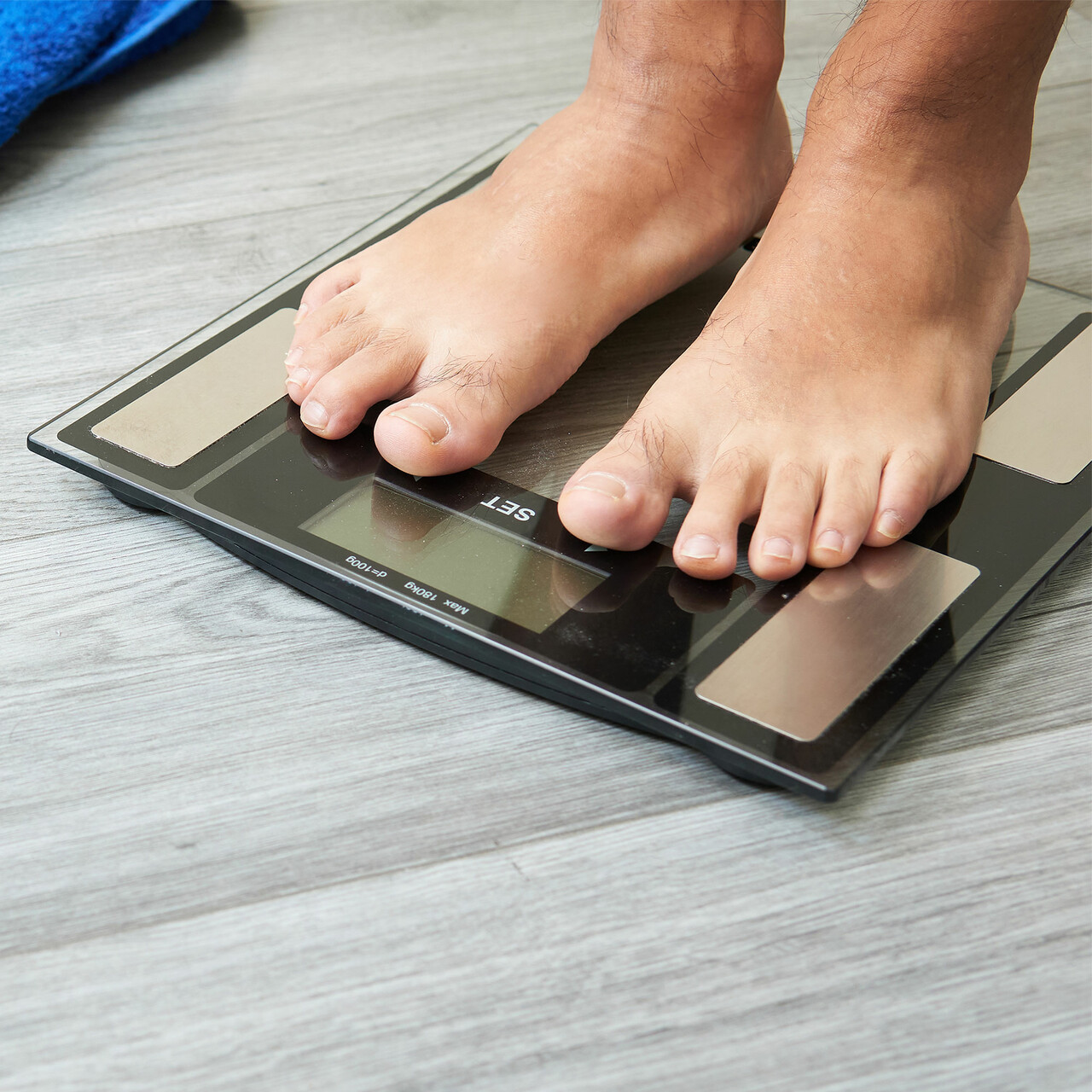 某人站在磅秤上的景象