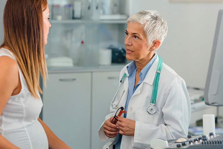 医生交谈,年轻的孕妇有关流感的风险。