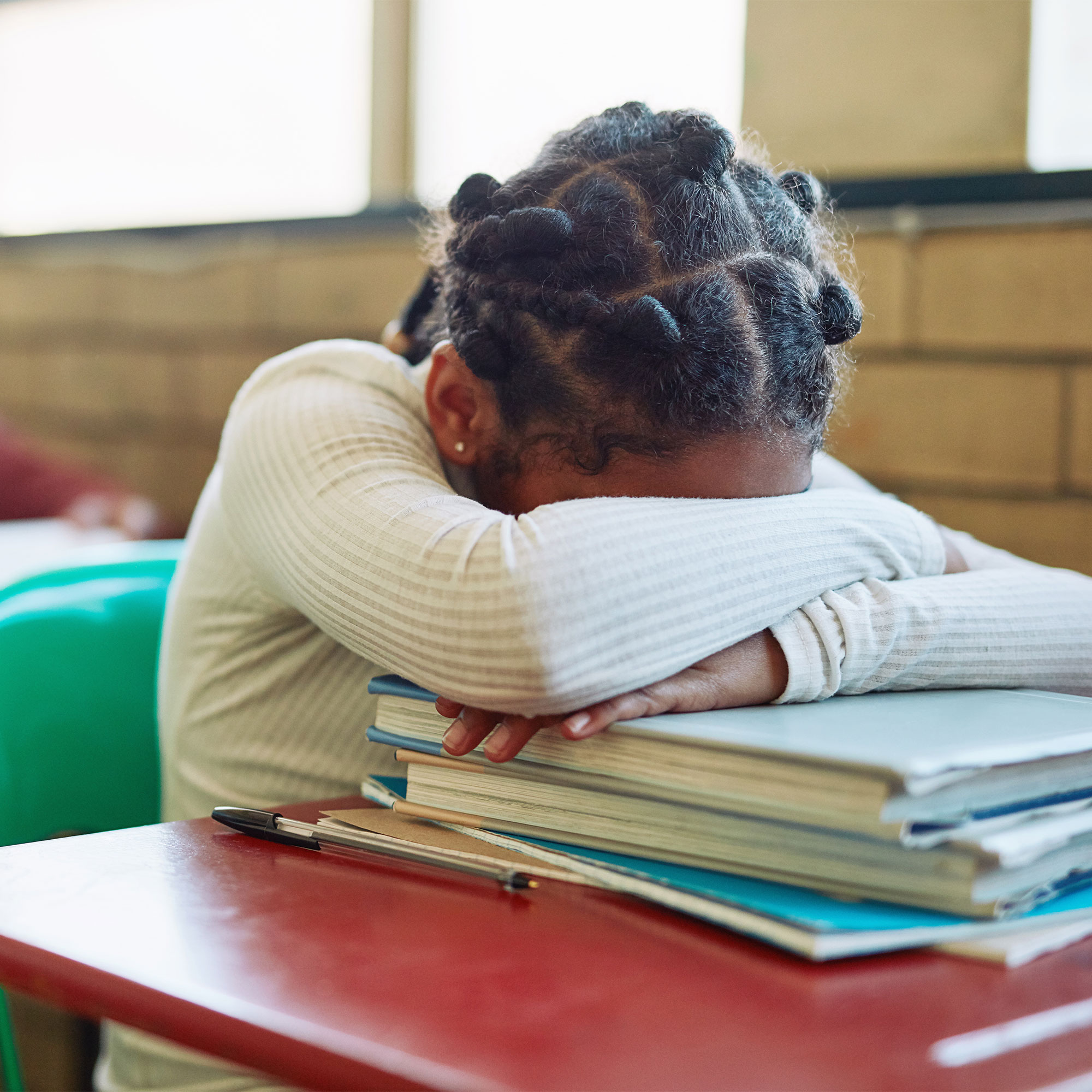 一个孩子在课堂上一直低着头坐在书桌前