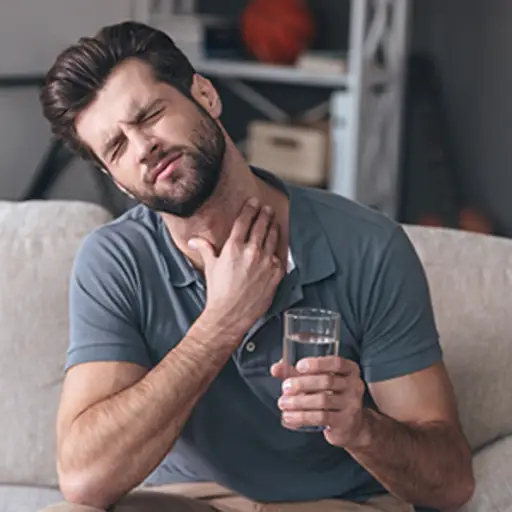 男人在喝一杯水时吞咽困扰。