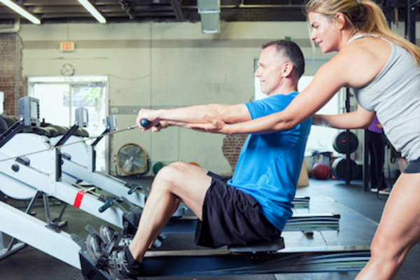 私人教练训练年长的男性客户。