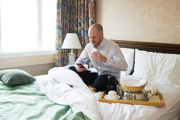 男士在提供客房服务的酒店房间休息。