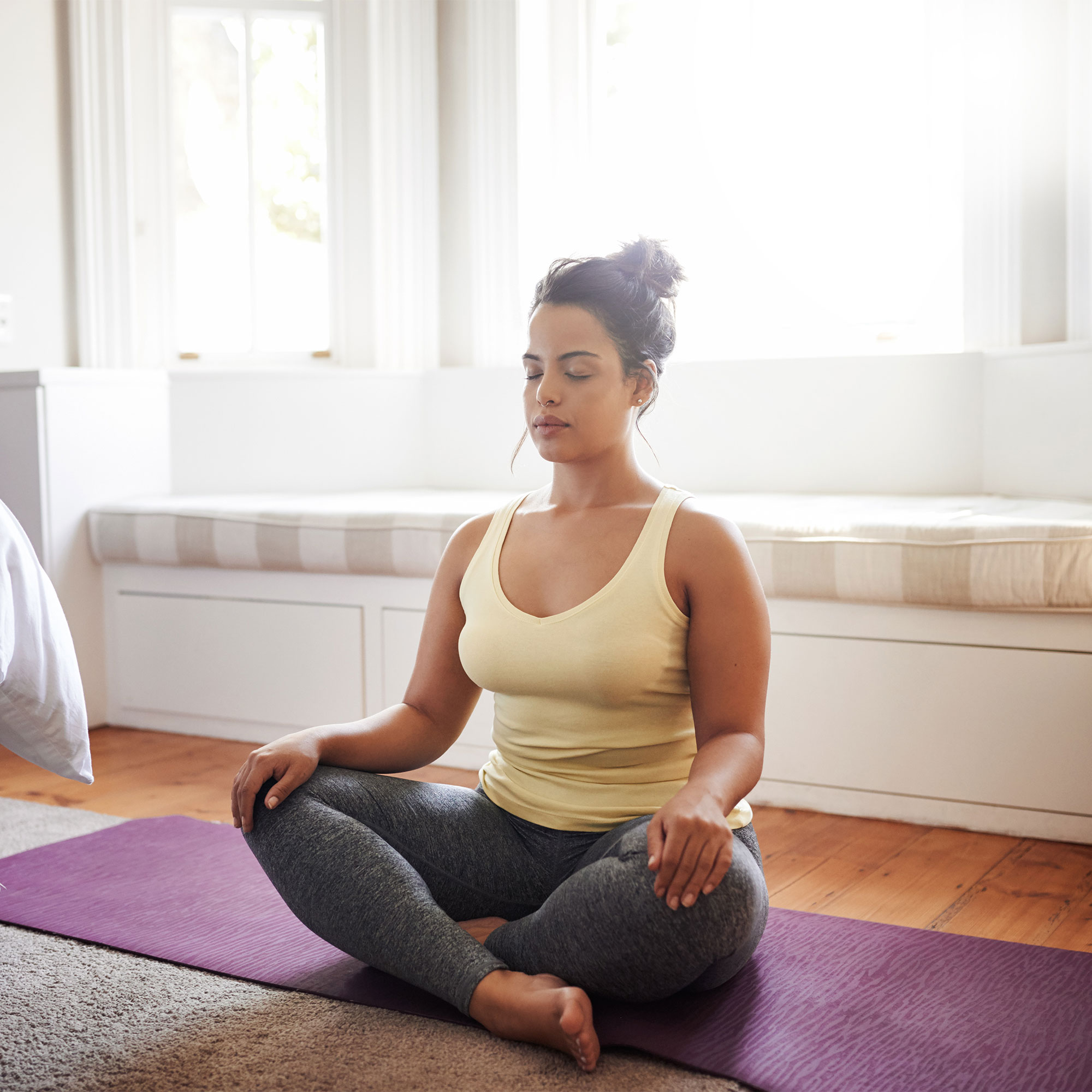 一个女人坐在瑜伽垫上