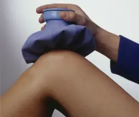 一名女子将冰袋放在膝盖上。