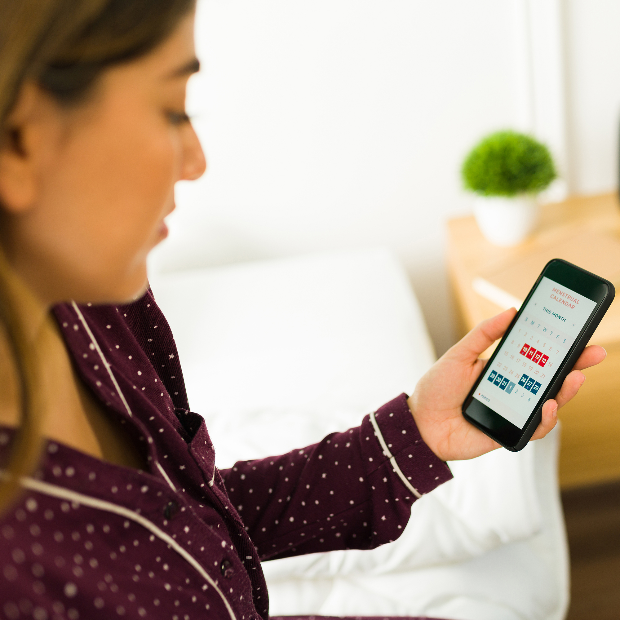 女人在智能手机上看她的月经历