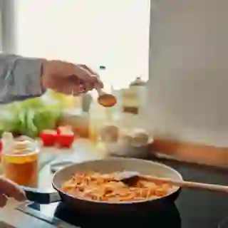 hand adding turmeric to cooking