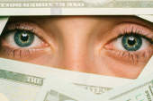 钱完全掩盖一个女人的脸，除了她的眼睛