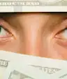 money completely obscuring a woman's face except her eyes