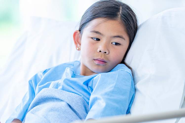 年轻的女孩在医院的病床上。