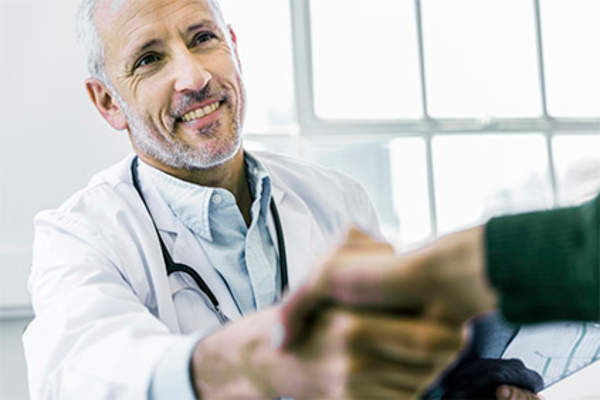 医生微笑摇晃病人的手。