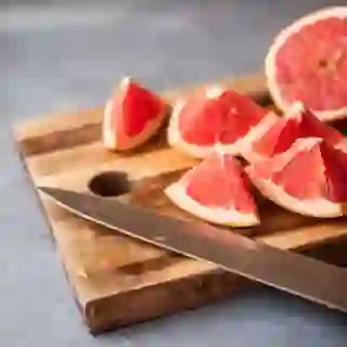 grapefruit and knife on cutting board