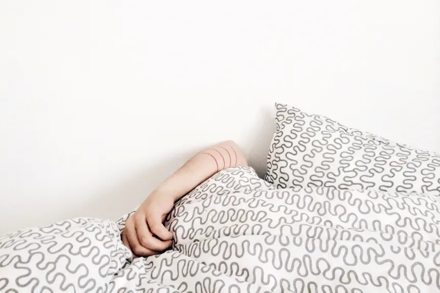 Woman sleeping with her arm over her head.