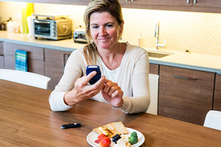 糖尿病患者女人餐前检查她的血糖。