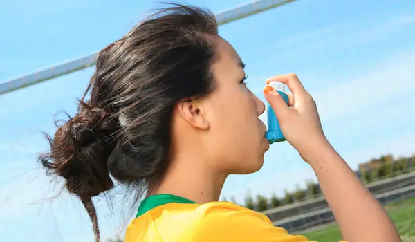 一名小学生在足球场使用吸入器。