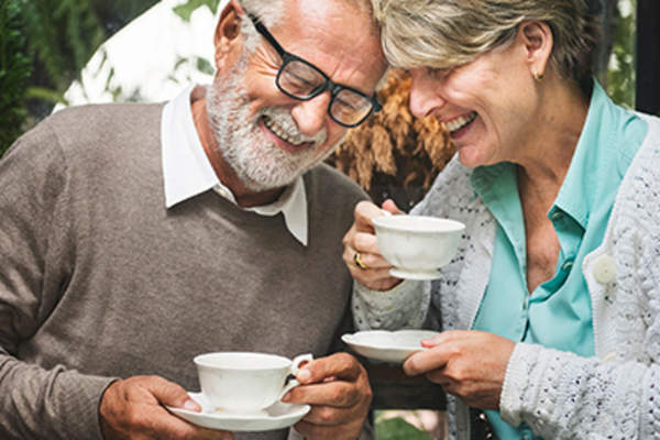 一对中年夫妇微笑、交谈、喝茶。