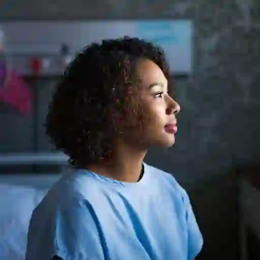 一位年轻的女病人坐在医院的检查室里