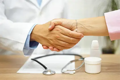 一位女士和她的医生握手。