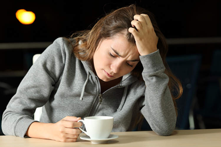 年轻女子有一杯咖啡的焦虑。