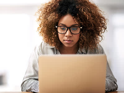 年轻女子使用笔记本电脑。