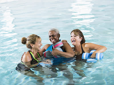 微笑的女人在水中有氧健身班。