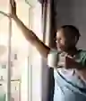 一个拿着咖啡杯的男人望着窗外