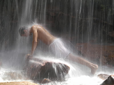 一个男人在水疗中心的瀑布下做按摩。