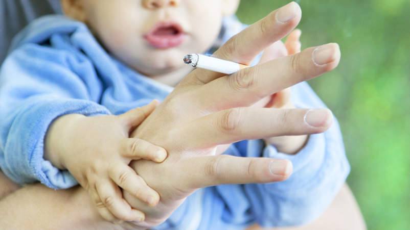 婴幼儿由家长抽着烟暴露于二手烟。
