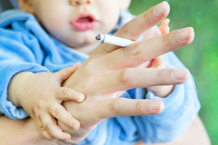 婴幼儿由家长抽着烟暴露于二手烟。
