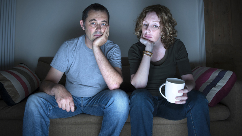 Bored couple watching television.