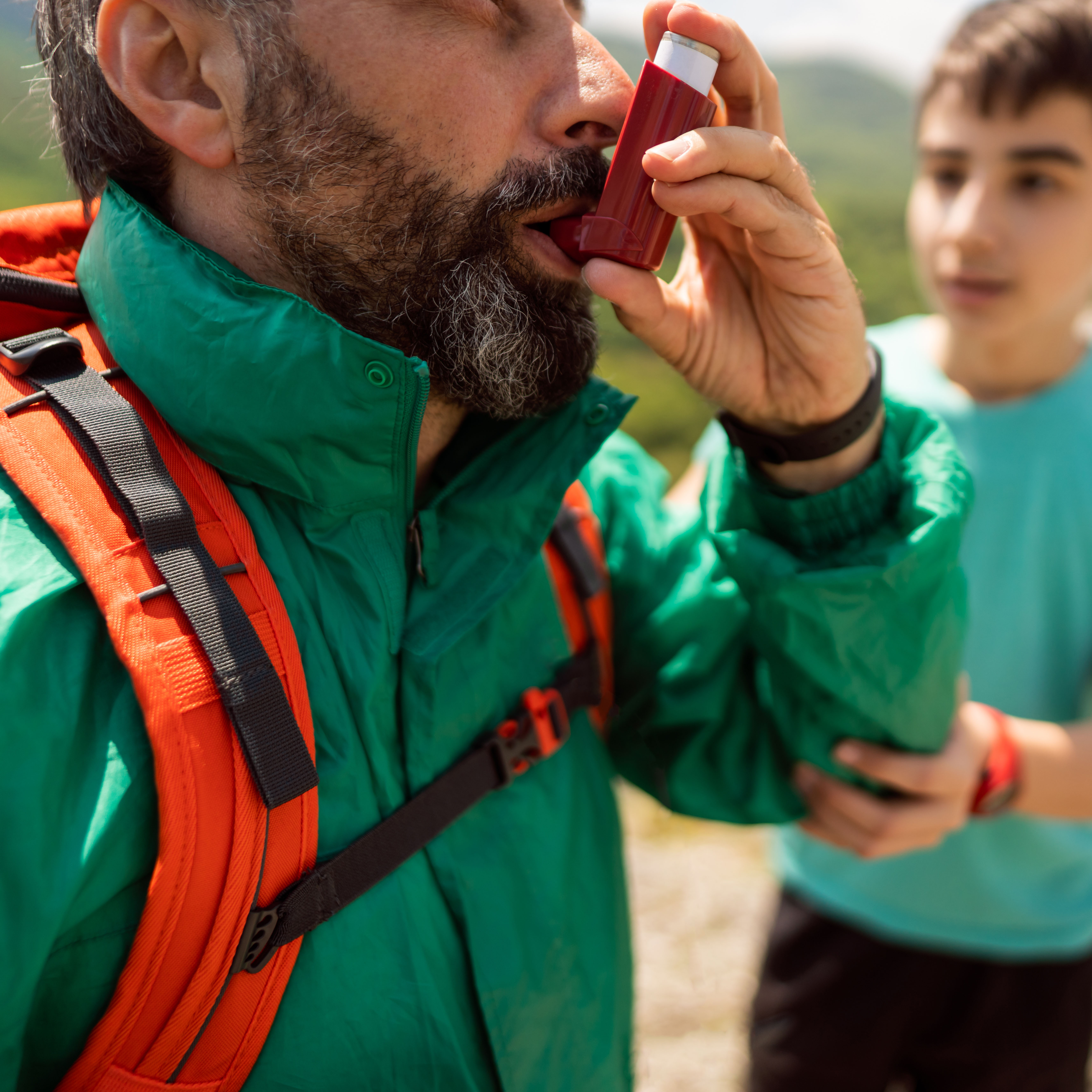 徒步旅行中使用吸入器的男子