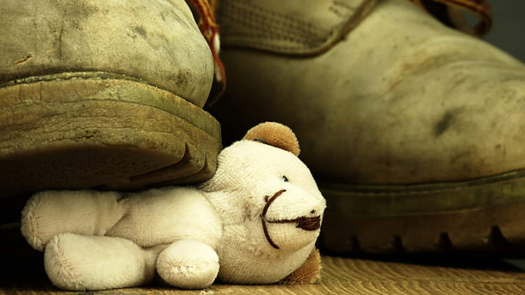 童年虐待，一只靴子踩在泰迪熊上。