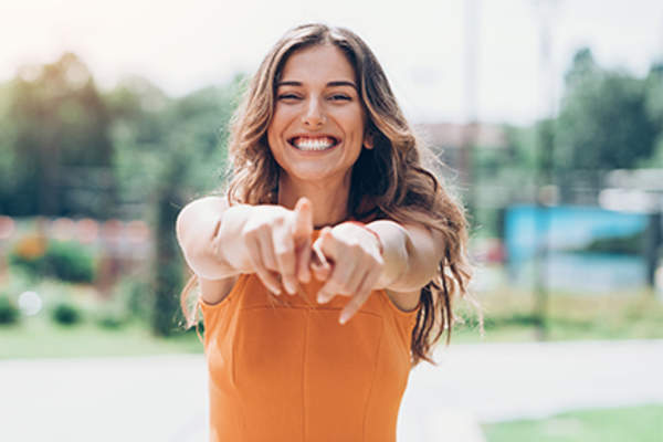 快乐的年轻女子指指点点,你是值得的概念。