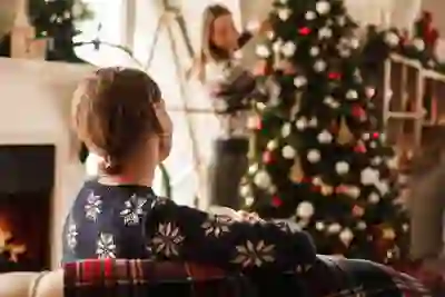 一个女人坐着看女儿装饰圣诞树