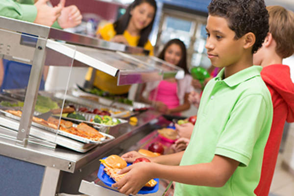 中学生在自助餐厅排队买午餐。