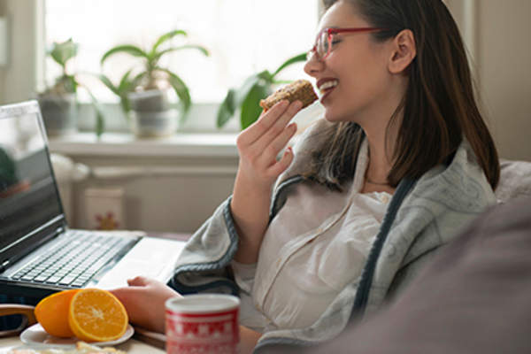 在办公桌前吃饭的女人。