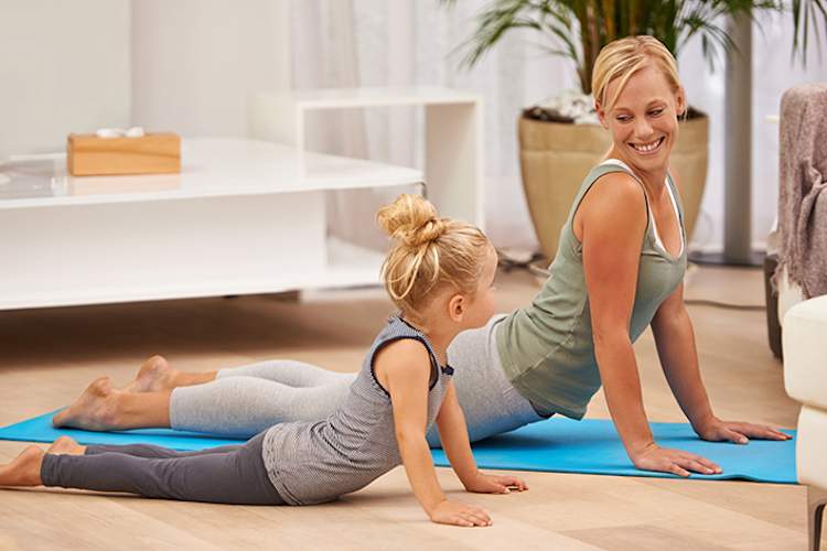 母亲和女儿做瑜伽在一起。