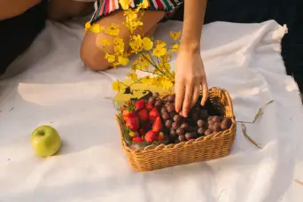 hand reaching for fruits in basket