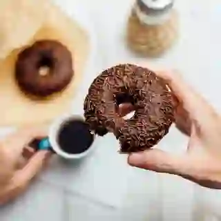 Hand holding a chocolate doughnut