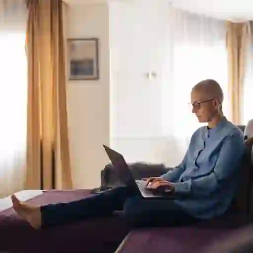 一位癌症患者在家里看她的笔记本电脑