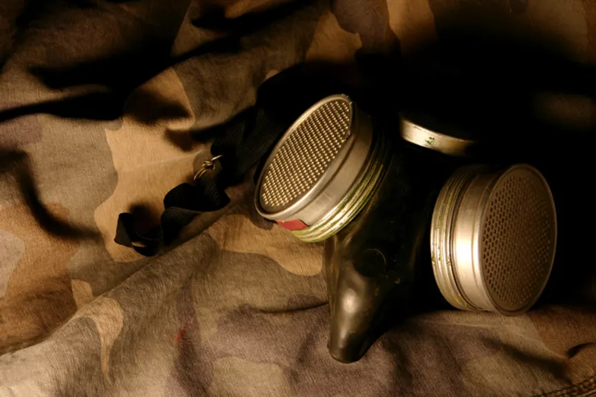 Gas mask laid on camouflage fabric.