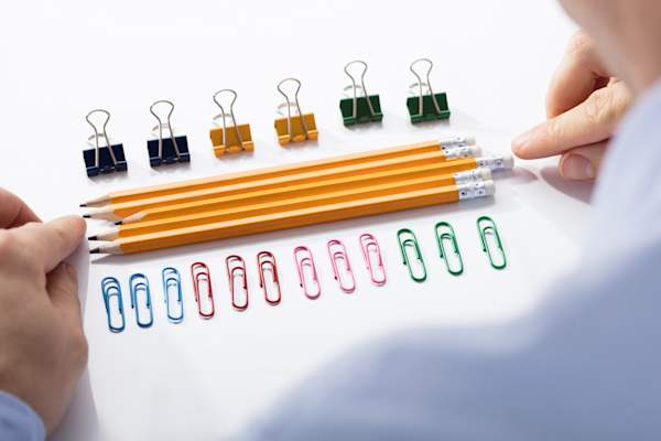 商人安排铅笔在七彩引脚之间“>
</picture>
</header>
<figcaption class=