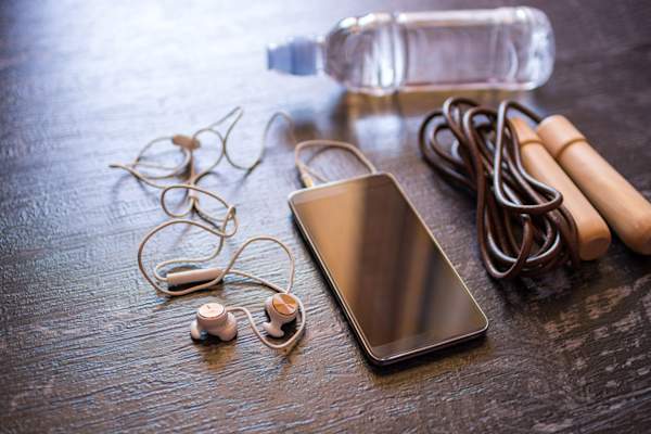 健身设备和智能手机上的黑色木制背景