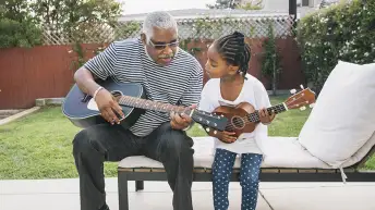 祖父和孙女一起弹吉他。