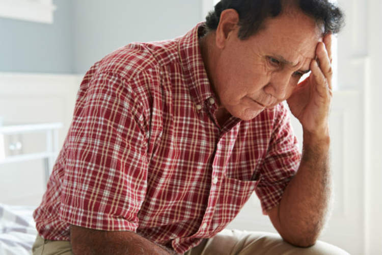 男子坐在床上思考