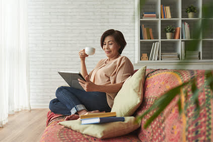 女人在沙发上放松在家，读书，喝喝茶。